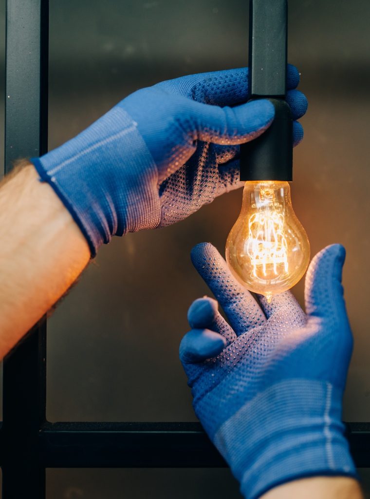 Electrician changes the light bulb, handyman